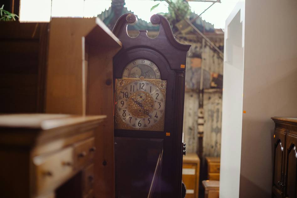 Vintage grandfather clock beside a fireplace